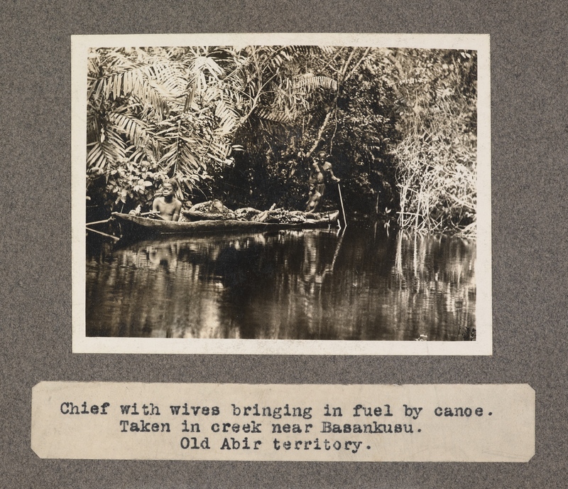 Chief with wives bringing in fuel by canoe. Taken in creek near Basankusu. Old Abir territory